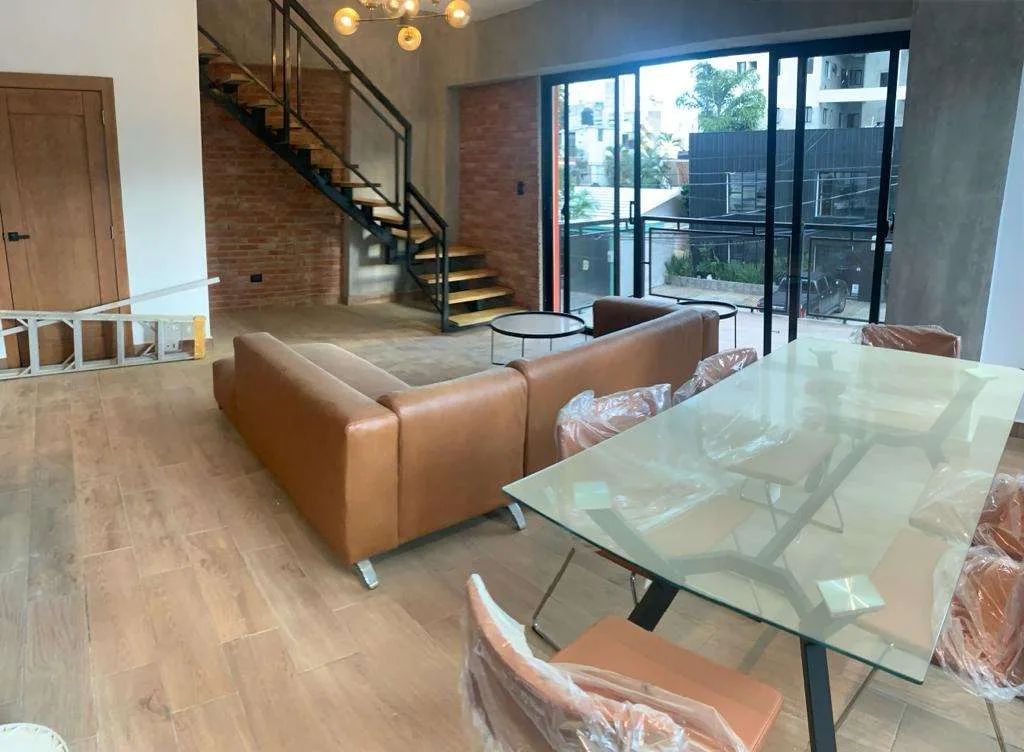 Loft con escalera metálica y comedor en iLoft Residence, foto real
